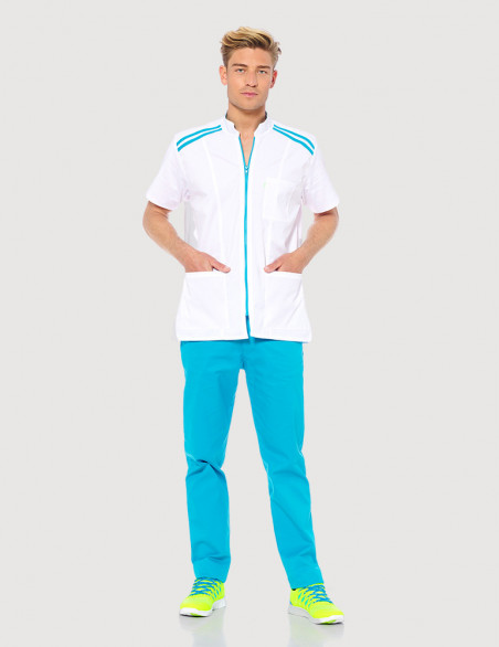Blouse médicale homme Loris Blanc avec parements Bleu Océan. Vue en pied. Portée avec pantalon bleu océan. Marque Belissa