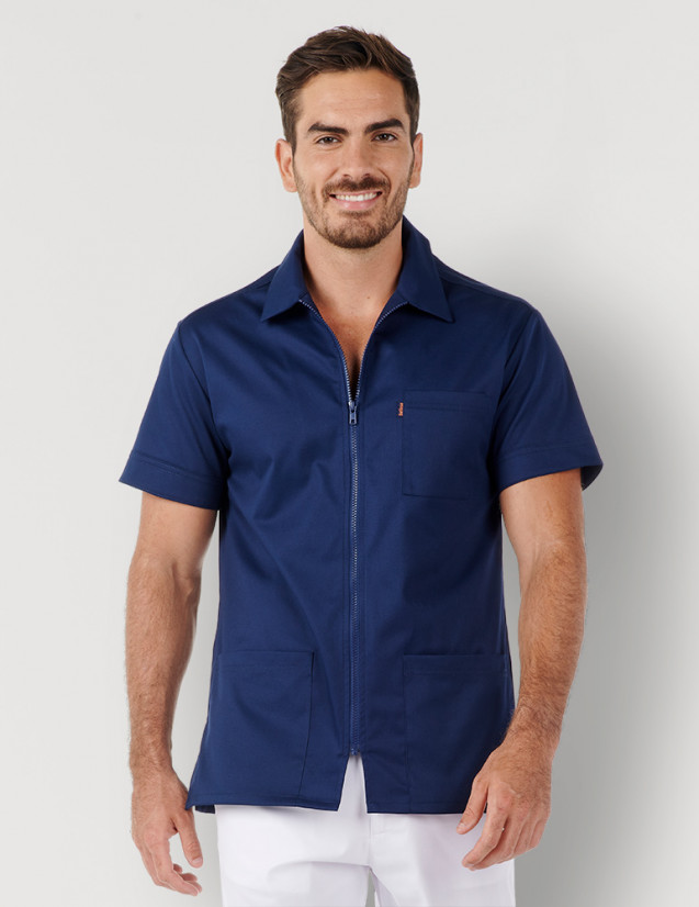 Homme avec blouse médicale couleur bleu marine à manches courtes, avec col chemise et zip. Marque Belissa Medical style