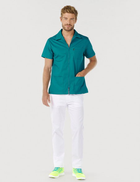 Homme avec blouse médicale bleu canard à manches courtes et col chemise. Pantalon blanc. Marque Belissa Medical style