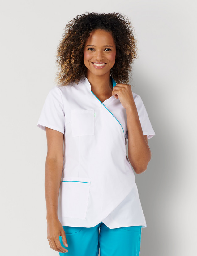 Femme avec blouse médicale couleur blanc et bleu océan à manches courtes, coupe asymétrique. Marque Belissa Medical style