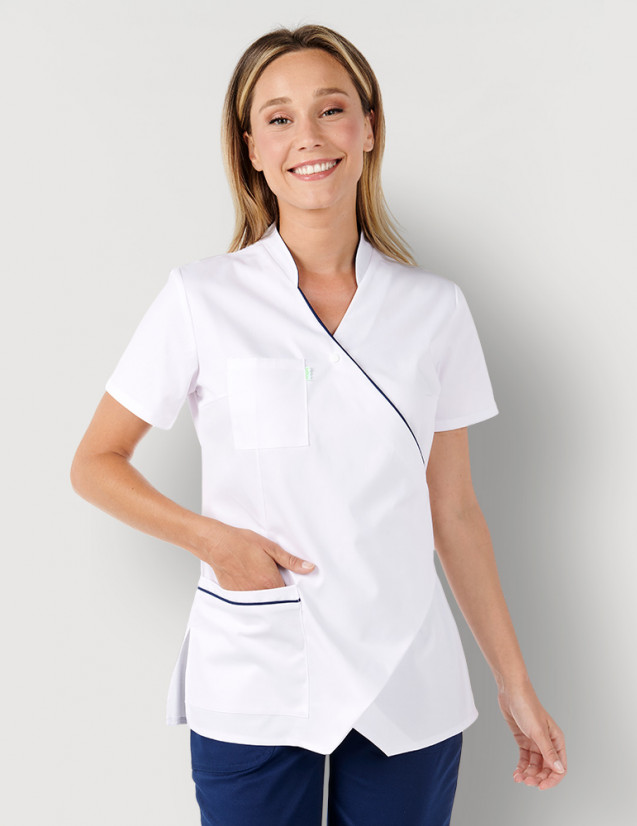 Femme avec blouse médicale couleur blanc et bleu marine à manches courtes, coupe asymétrique. Marque Belissa Medical style