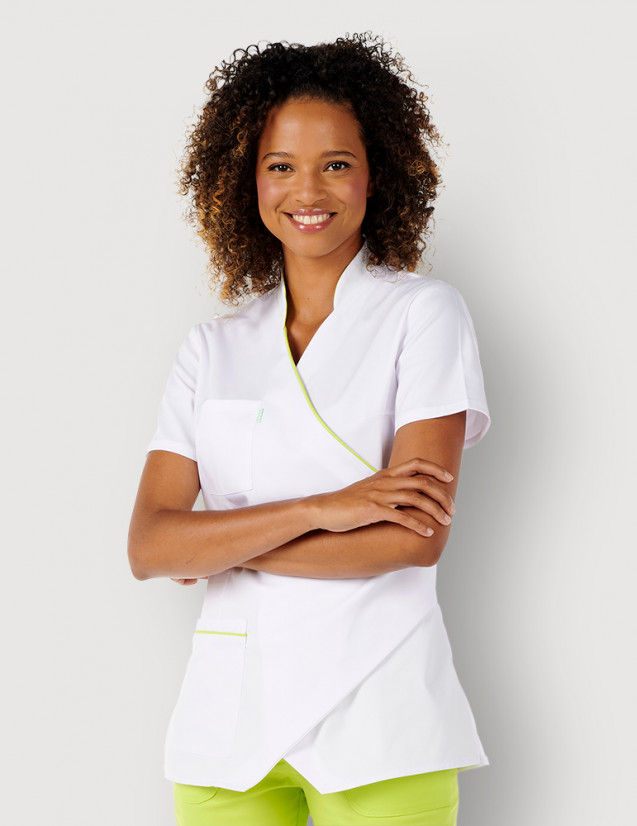 Femme avec blouse médicale couleur blanc et vert anis à manches courtes, coupe asymétrique. Marque Belissa Medical style