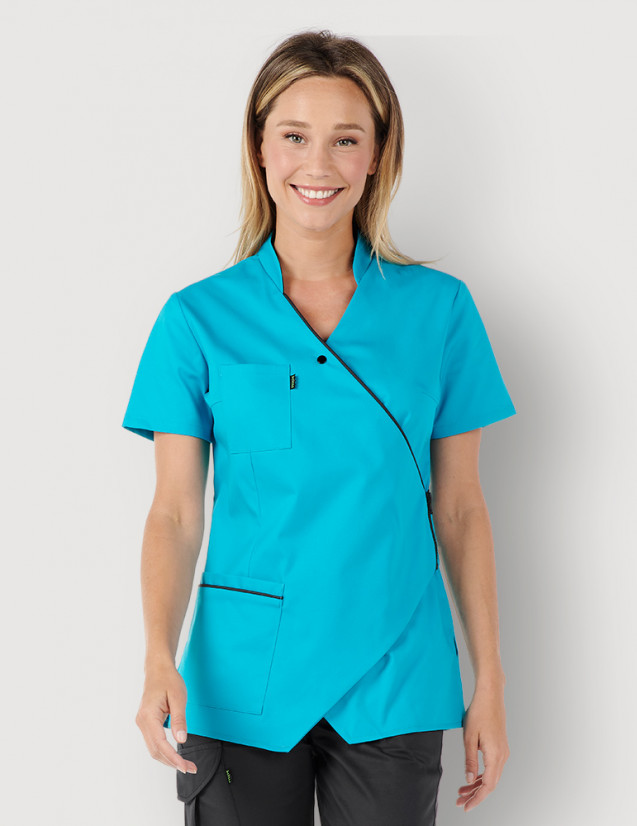 Femme avec blouse médicale couleur bleu océan et ardoise, manches courtes, coupe asymétrique. Marque Belissa Medical style