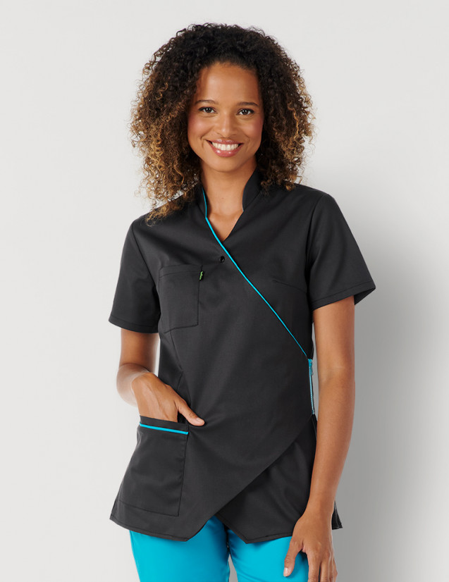 Femme avec blouse médicale couleur ardoise et bleu océan manches courtes, coupe asymétrique. Marque Belissa Medical style