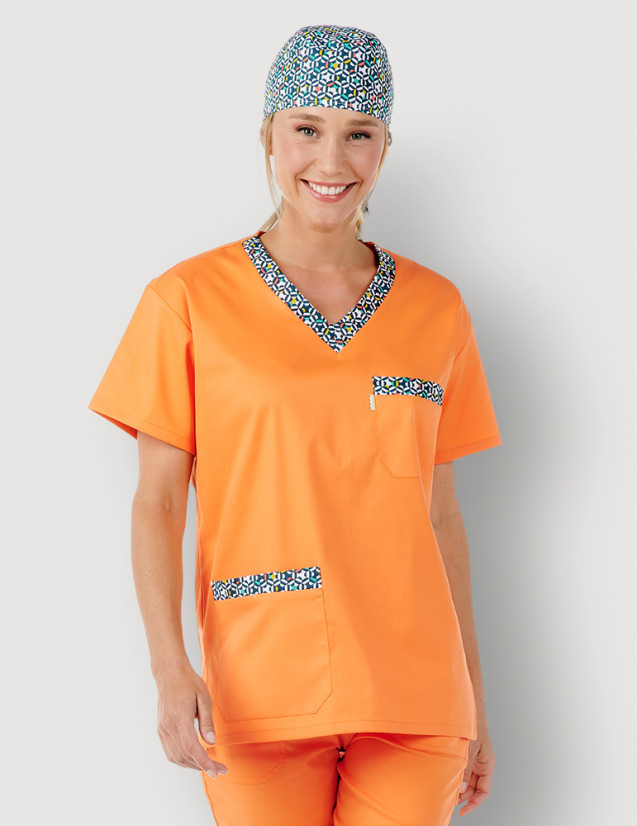 Femme en tunique médicale unisexe Jules couleur abricot + motifs "graphic" by Belissa. Portée avec calot motifs Graphic
