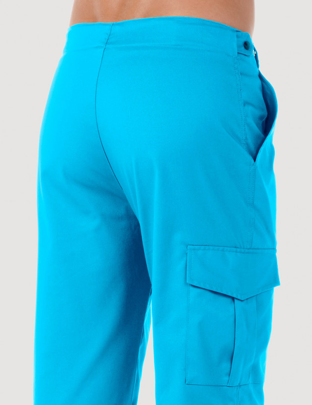 Pantalon médical homme avec poche treillis sur la jambe droite. Vue de dos - Couleur bleu océan - Modèle Luis - Marque Belissa Pantalon médical homme avec poche treillis sur la jambe droite. Vue de dos - Couleur bleu océan - Modèle Luis - Marque Belissa
