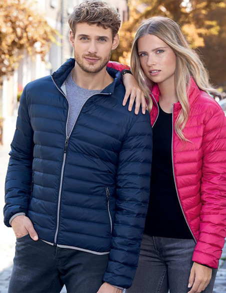 Veste matelassée bleu marine homme et veste matelassée rose femme. Vue portées en couple en extérieur. Doudounes