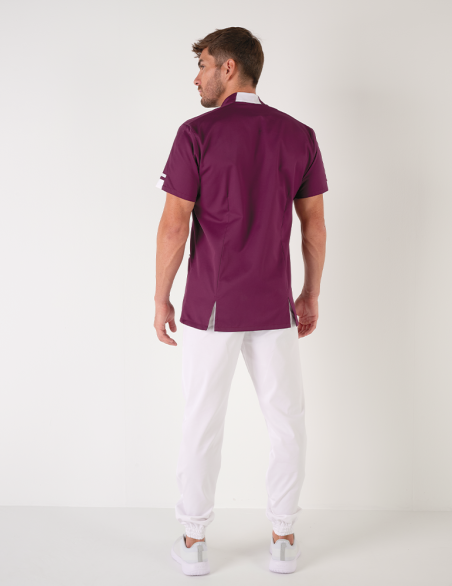 Blouse médicale homme Marley, cassis avec parements blanc. Portée avec un pantalon blanc. Marque Belissa