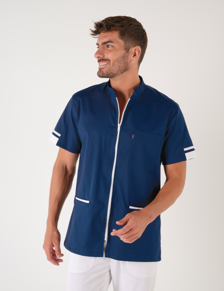 Blouse médicale homme Marley, bleu marine avec parements blanc. Portée avec un pantalon blanc. Marque Belissa