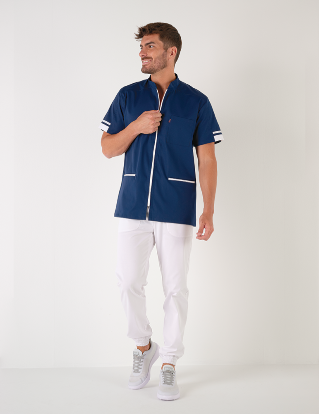 Blouse médicale homme Marley, bleu marine avec parements blanc. Portée avec un pantalon blanc. Marque Belissa Blouse médicale homme Marley, bleu marine avec parements blanc. Portée avec un pantalon blanc. Marque Belissa